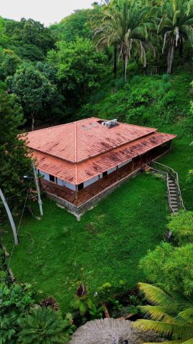 a building with a red roof on a green field at EcoHotel Inka Minka in Santa Marta