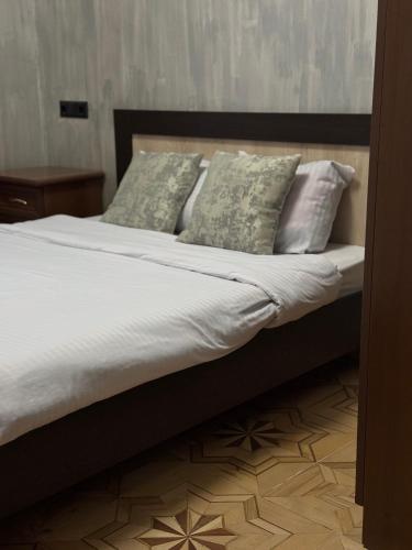 a bed with white sheets and pillows on it at Madoyans Rest House in Antarut