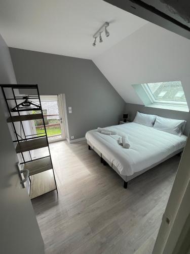 - une chambre avec un lit blanc et une échelle dans l'établissement Les Maisons de Lessac, à Guérande