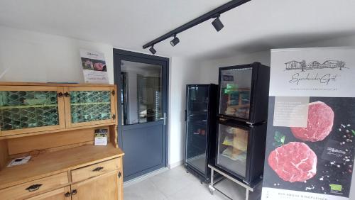 a kitchen with two refrigerators and a counter and a refrigerator at Ferienwohnung am Sperchenedergut in Aspach