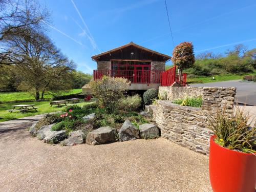 a building with a red gate and a stone wall at Le Moulin de Drapras in Chemillé