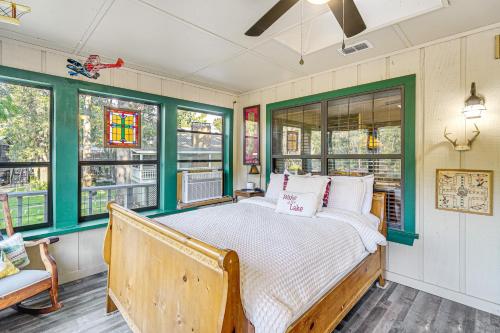 ein Schlafzimmer mit einem Bett in einem Zimmer mit Fenstern in der Unterkunft Lakefront Home Deck, Grills and Fire Pit in Karnack in Karnack