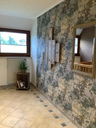 a room with a wall with wallpaper and a mirror at Ferienwohnung Hümmling in Börger