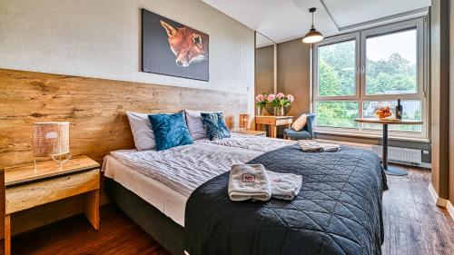 a bedroom with a large bed with a wooden wall at Apartament 26 Resort Kozubnik blisko Szczyrk - 5D Apartamenty in Porąbka
