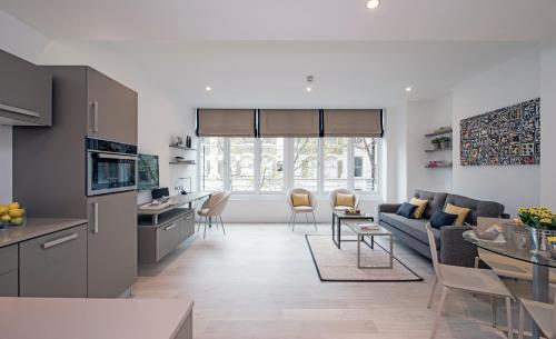 uma cozinha e sala de estar com um sofá e uma mesa em The Rosebery by Supercity Aparthotels em Londres