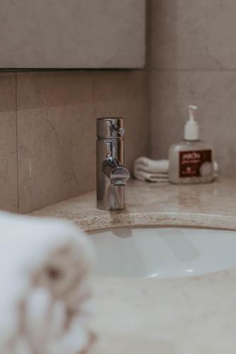 a bathroom sink with a faucet on a counter at Millenium Plaza & Suites in San Luis Potosí