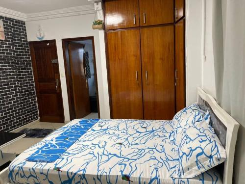 sypialnia z łóżkiem z niebiesko-białą kołdrą w obiekcie Henock résidence w mieście Abidżan