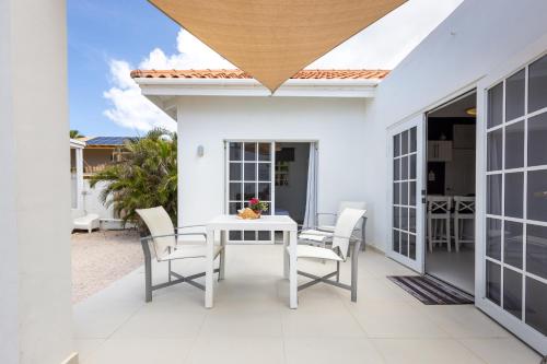 a white patio with a white table and chairs at Artiko Luxury Suites - Jan Thiel in Jan Thiel