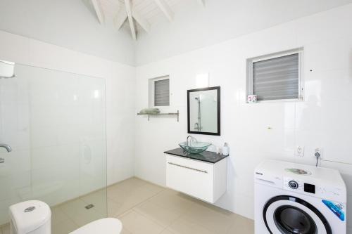 a white bathroom with a washer and dryer at Artiko Luxury Suites - Jan Thiel in Jan Thiel