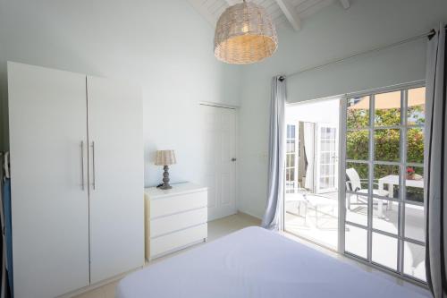 a bedroom with white walls and a large sliding glass door at Artiko Luxury Suites - Jan Thiel in Jan Thiel
