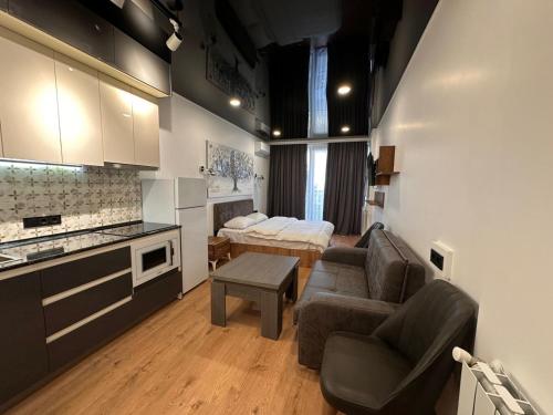 a kitchen and a living room with a couch and a table at Next apartments "Seaside" in Batumi