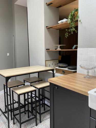 - une cuisine avec une table et quelques tabourets dans l'établissement Appartement 1 - La Maison Augustine, à Hem