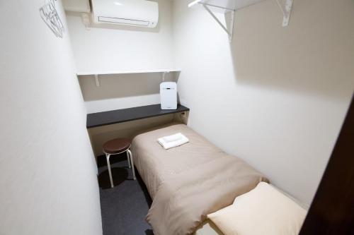 a small room with a small bed and a stool at Aikoku Building 5th floor - Vacation STAY 86252v in Tokyo