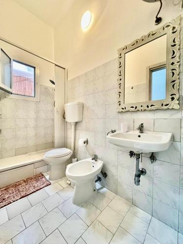 a bathroom with a toilet and a sink and a mirror at Gens Fulvia Brindisi in Brindisi