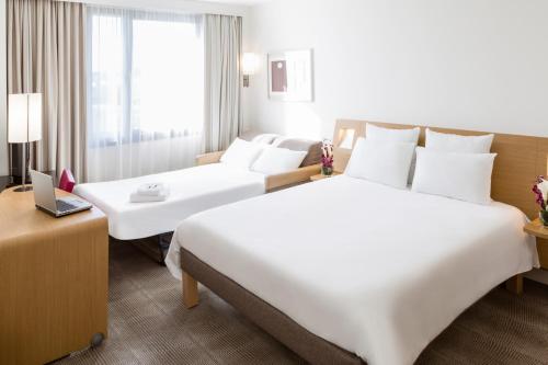 a hotel room with two beds and a window at Novotel Paris Créteil Le Lac in Créteil