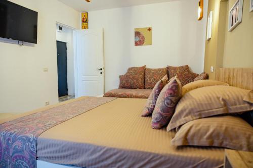 a bedroom with a large bed and a couch at Cochet Studio in Focşani