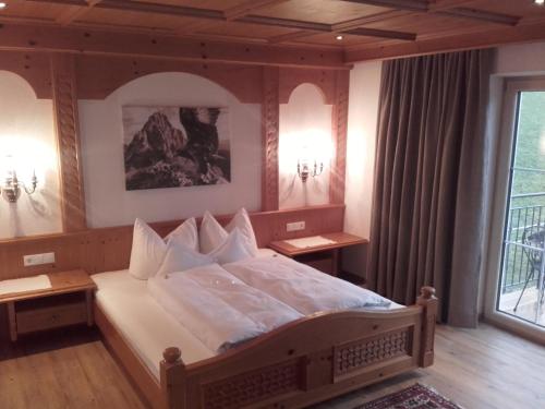 ein Schlafzimmer mit einem großen Bett und einem Fenster in der Unterkunft Tirol Appartement Haus Zillertal in Zell am Ziller