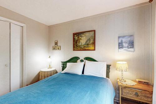 una camera da letto con un letto con una coperta blu di Skyleaf E4 a Sugar Mountain
