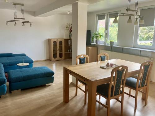 a living room with a table and a blue couch at Star Camp Cosa, Ferienwohnungen, Camping, Schlaffässer in Friedland