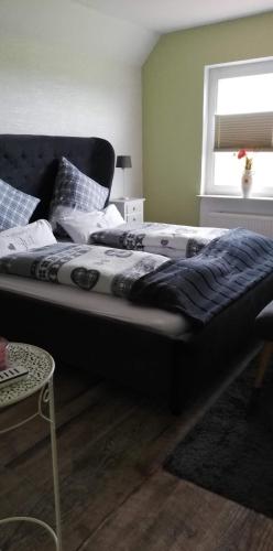 a large bed in a bedroom with a window at Landhaus Löwenzahn in Dornum