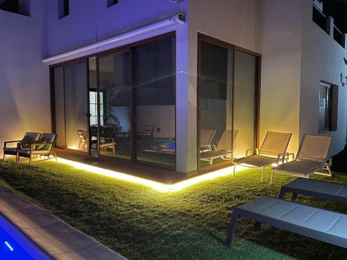 a patio with chairs and lights in front of a building at Villa Tama Luxury & Relax in Costa Teguise