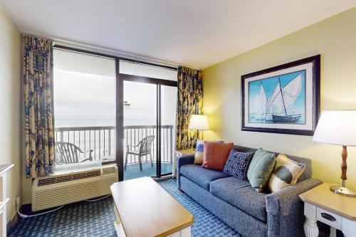 a living room with a couch and a large window at Oceanfront Paradise in Myrtle Beach