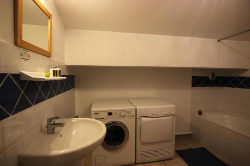 une salle de bain avec une machine à laver et un lavabo dans l'établissement Résidence Le Peclet - VAL THORENS SPACIEUX APPARTEMENT POUR 10 PERSONNES, EXPOSE SUD, BELLE VUE DEGAGEE MAE-7436, à Val Thorens