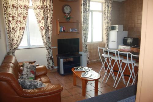 a living room with a couch and a table and a kitchen at Governor's Inn Apartments in Gibraltar