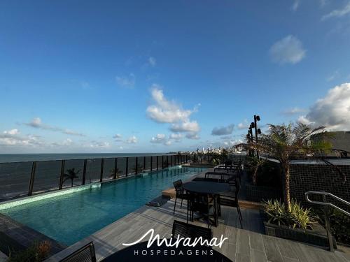 a swimming pool with a view of the ocean at Beach Haus in Tambaú