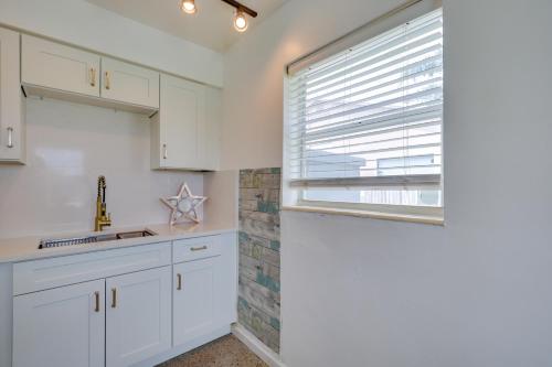ハリウッドにある3 Mi to Beach Quaint Home with Patio in Hollywoodの白いキャビネットと窓のあるキッチン