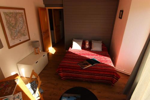 une petite chambre avec un lit avec une couverture rouge dans l'établissement Résidence Hauts De Chaviere - VAL THORENS SPACIEUX 4 PIECES 8 PERSONNES PROCHE DE TOUT MAE-7445, à Val Thorens