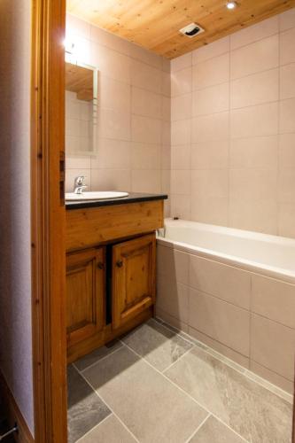 une salle de bain avec un lavabo et une baignoire dans l'établissement Résidence Bouquetin - 3 Pièces pour 6 Personnes 48, à Val Thorens