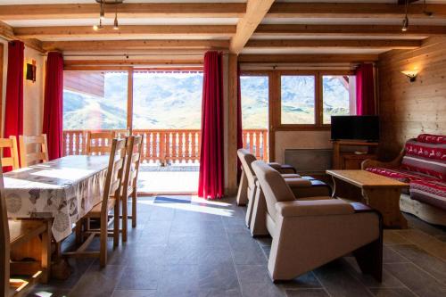 - un salon avec une table, des chaises et une grande fenêtre dans l'établissement Résidence Bouquetin - 3 Pièces pour 6 Personnes 48, à Val Thorens
