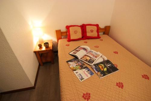 - une petite chambre avec un lit et des magazines dans l'établissement Résidence Beau Soleil - CHALET BEAUSOLEIL APPARTEMENT 6 PERS 50M² JOLIE VUE MAE-7454, à Val Thorens