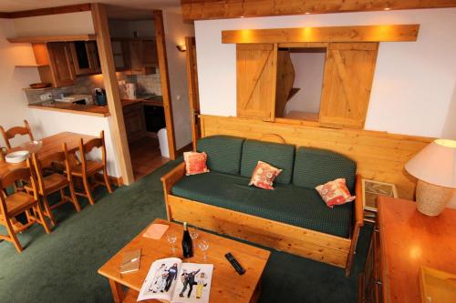 un salon avec un canapé vert et une table dans l'établissement Chalet Le Cristallo - CHALET CRISTALLO APPARTEMENT 50M² 6 PERS JOLIE VUE MAE-7466, à Val Thorens