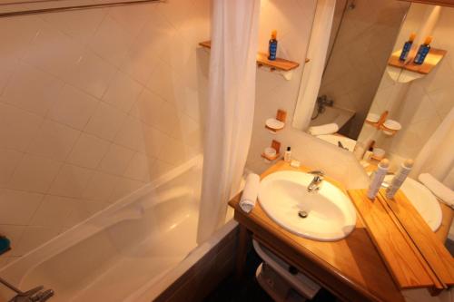 une salle de bain avec un lavabo, un miroir et une baignoire dans l'établissement Chalet Le Cristallo - CHALET CRISTALLO APPARTEMENT 50M² 6 PERS JOLIE VUE MAE-7466, à Val Thorens
