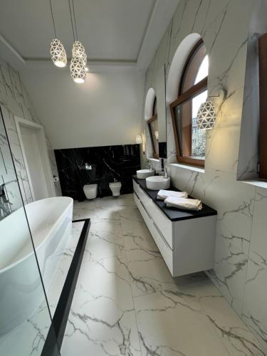 a bathroom with two sinks and a tub and a mirror at Yeti Apartamenty Krupówki 73C in Zakopane