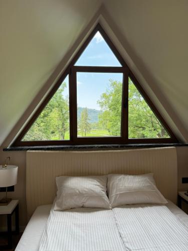 a bed in a room with a large window at Yeti Apartamenty Krupówki 73C in Zakopane