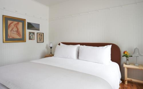a white bedroom with a large bed with white pillows at The Drifthaven at Gearhart in Gearhart