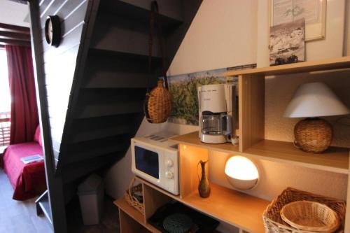 une petite cuisine avec un four micro-ondes sur une table dans l'établissement Résidence Silveralp - VAL THORENS APPARTEMENT 5 PERSONNES PARFAIT POUR FAMILLE MAE-7527, à Val Thorens