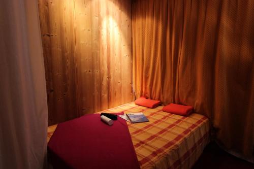 - une petite chambre avec un lit et des oreillers rouges dans l'établissement Résidence Neves - VAL THORENS AGREABLE 2 PIECES POUR 5 PERSONNES AU COEUR QUARTIER ANIME DE LA STATION MAE-7528, à Val Thorens