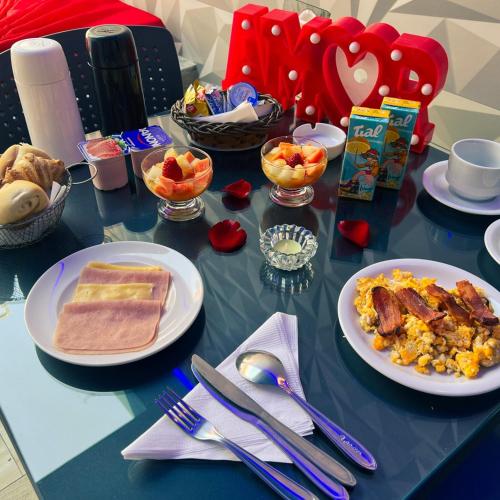 un tavolo con sopra piatti di cibo per la colazione di Motel Belle (Adult Only) a San Paolo