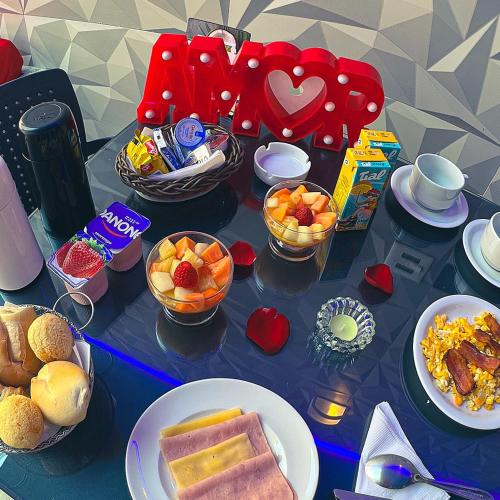 una tavola ricoperta di piatti di cibo e frutta di Motel Belle (Adult Only) a San Paolo