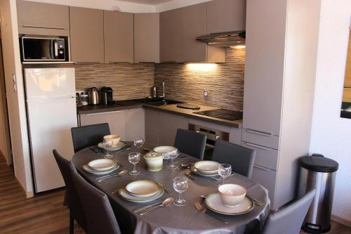 une table de salle à manger avec des chaises et une cuisine dans l'établissement Résidence Trois Vallees - TROIS VALLEES APPARTEMENT TRES BIEN SITUE MAE-7568, à Val Thorens