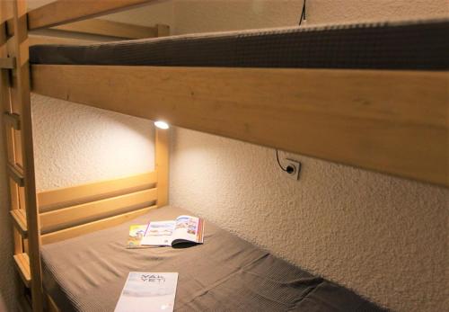 - un livre assis au-dessus d'un lit superposé dans l'établissement Résidence Trois Vallees - TROIS VALLEES APPARTEMENT TRES BIEN SITUE MAE-7568, à Val Thorens
