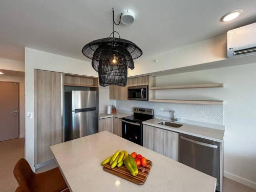 a kitchen with a table with fruits and vegetables on it at Ocean Front, Luxurious Condo in Downtown Jaco! in Jacó