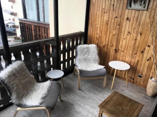 un balcon avec deux chaises et tables et une fenêtre dans l'établissement Résidence Serac - 2 PIECES CABINE POUR 4 PERSONNES EXPOSE SUD AU SEIN DU QUARTIER SLALOM MAE-7577, à Val Thorens
