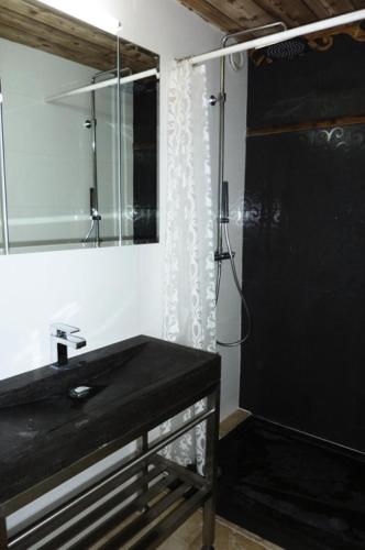 La salle de bains est pourvue d'un lavabo noir et d'une douche. dans l'établissement Résidence Lac Du Lou - VAL THORENS CONFORTABLE 2 PIECES 5 PERSONNES AU PIED DES PISTES MAE-7578, à Val Thorens
