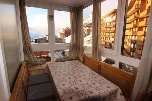 Cette chambre comprend un lit et une grande fenêtre. dans l'établissement Résidence Eskival - ESKIVAL APPARTEMENT 35M² 4 PERS CENTRE STATION ACCES DIRECT SUR LES PISTES MAE-7584, à Val Thorens