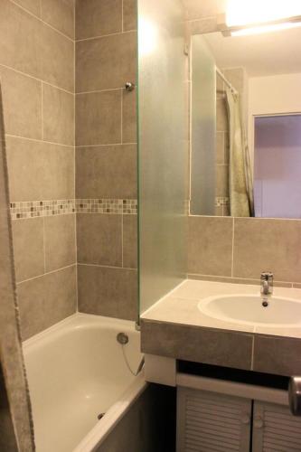 une salle de bain avec un lavabo, une baignoire et un miroir dans l'établissement Résidence Eskival - ESKIVAL APPARTEMENT 35M² 4 PERS CENTRE STATION ACCES DIRECT SUR LES PISTES MAE-7584, à Val Thorens